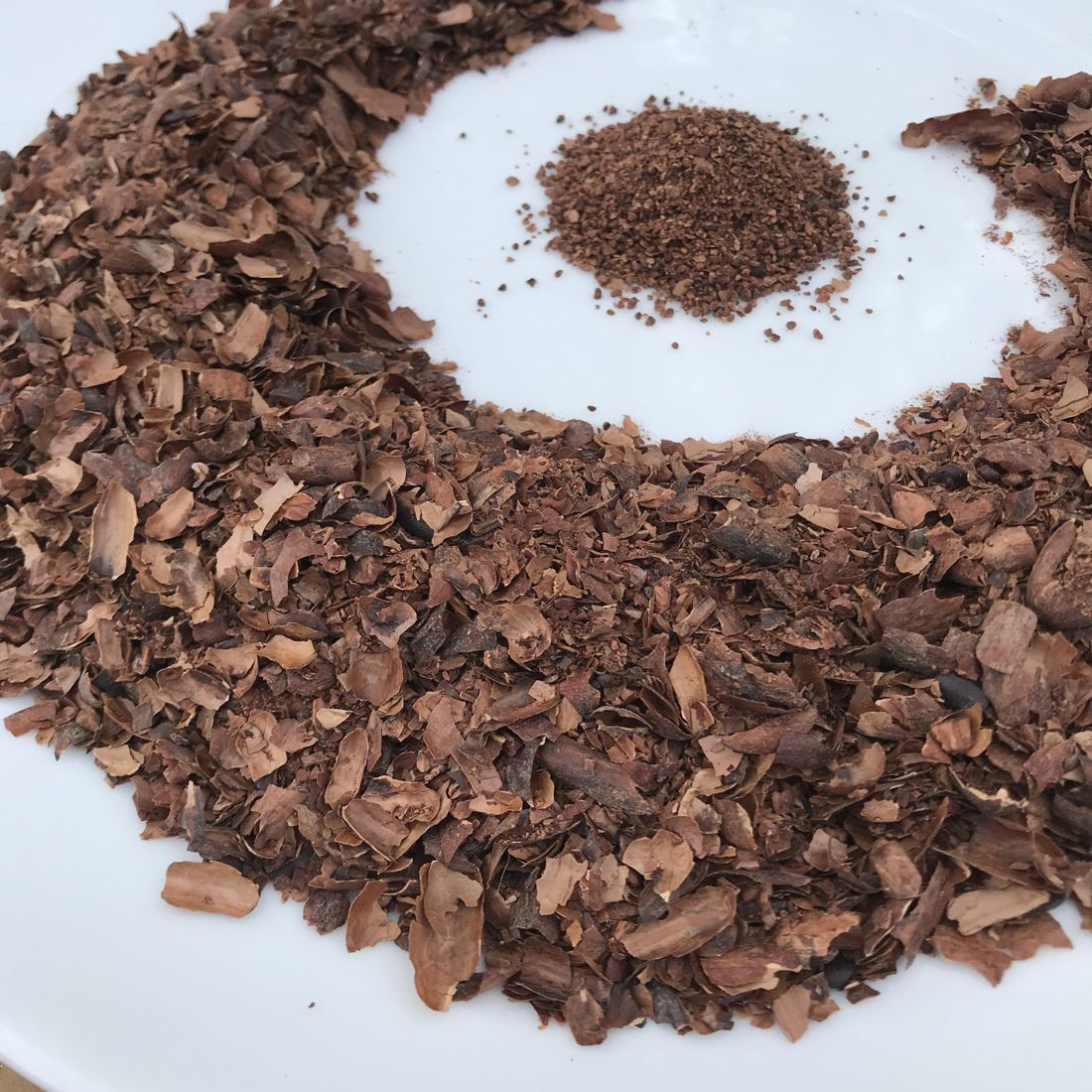 Roasted cacao shells, with a small pile ground for tea