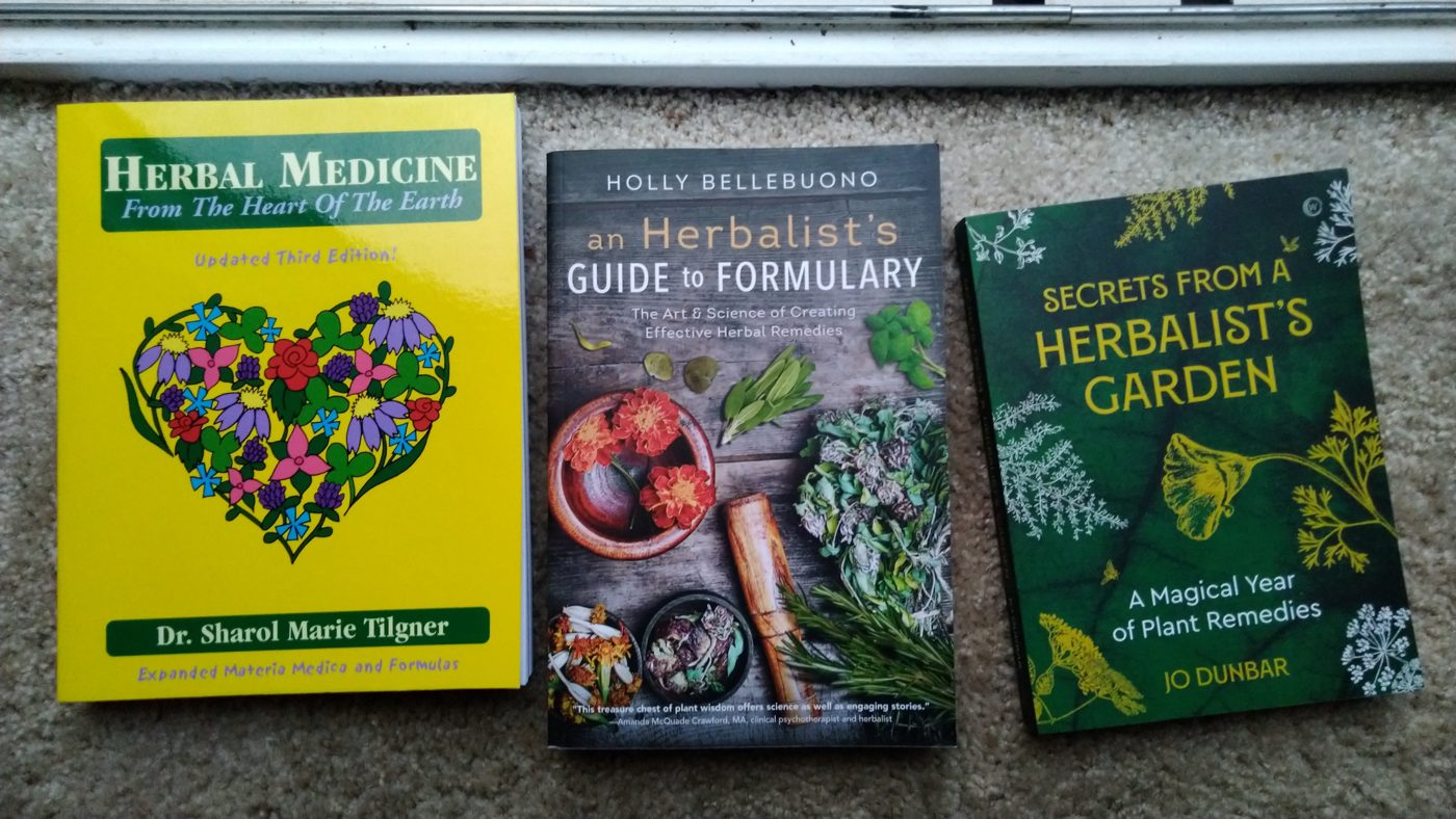 Three books on herbal medicine laid out side by side